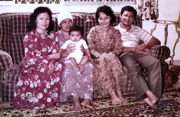 With his aunt, paternal grandmother and parents at eight months old